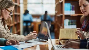 Dos personas en una mesa investigando