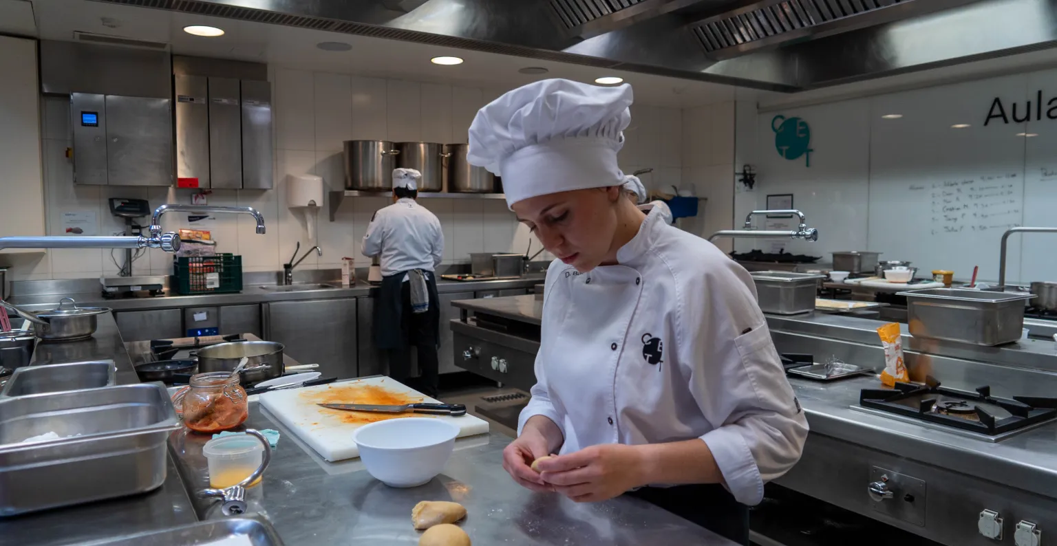 Una alumna preparando su plato en la cocina.