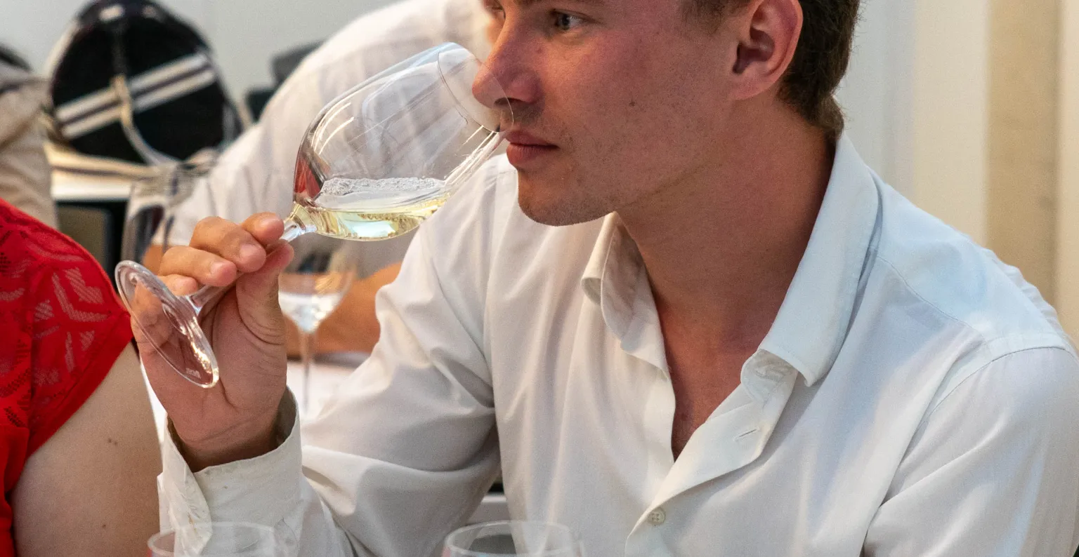 Un alumno oliendo un vino blanco