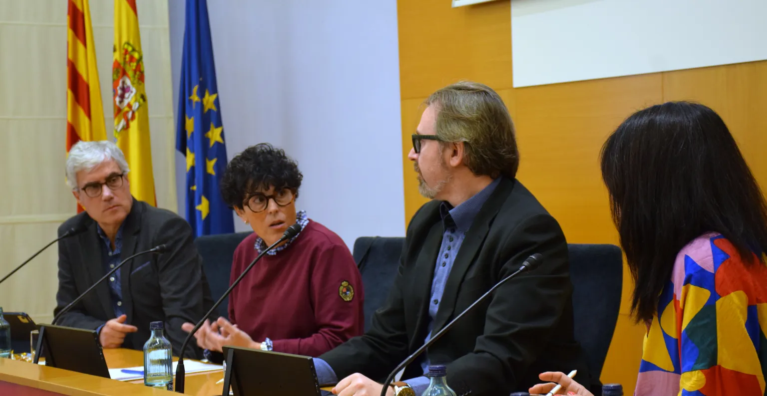 Imagen de los ponentes sentados en la mesa de debate