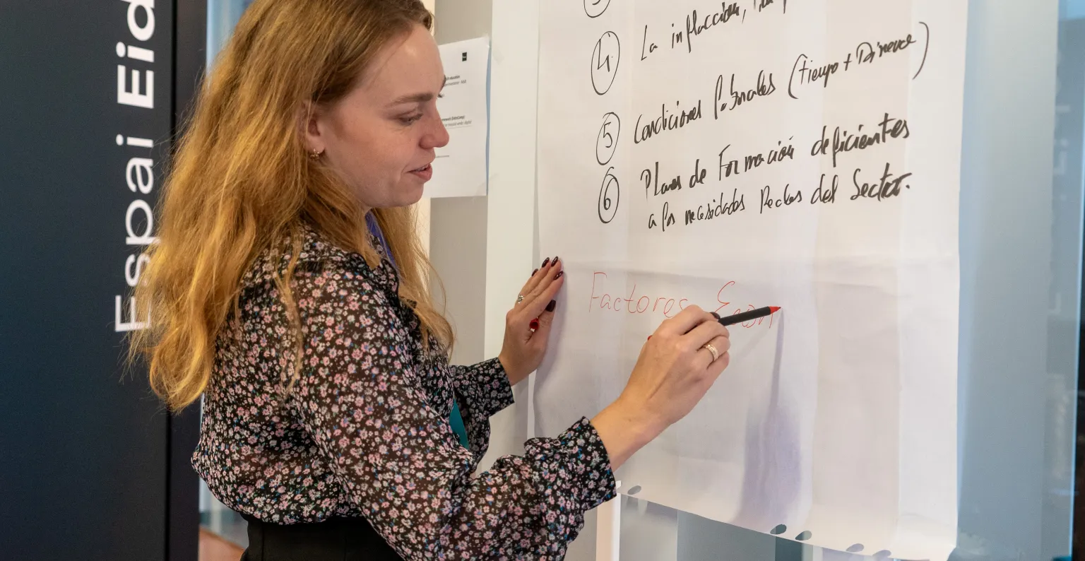 Persona escribiendo en la pizarra
