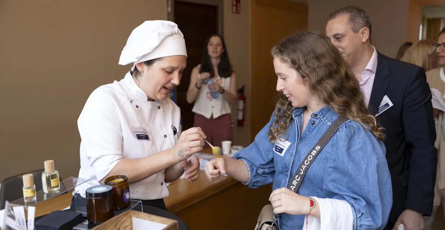 L'alumna aplica el producte sobre la mà d'una de les assistents