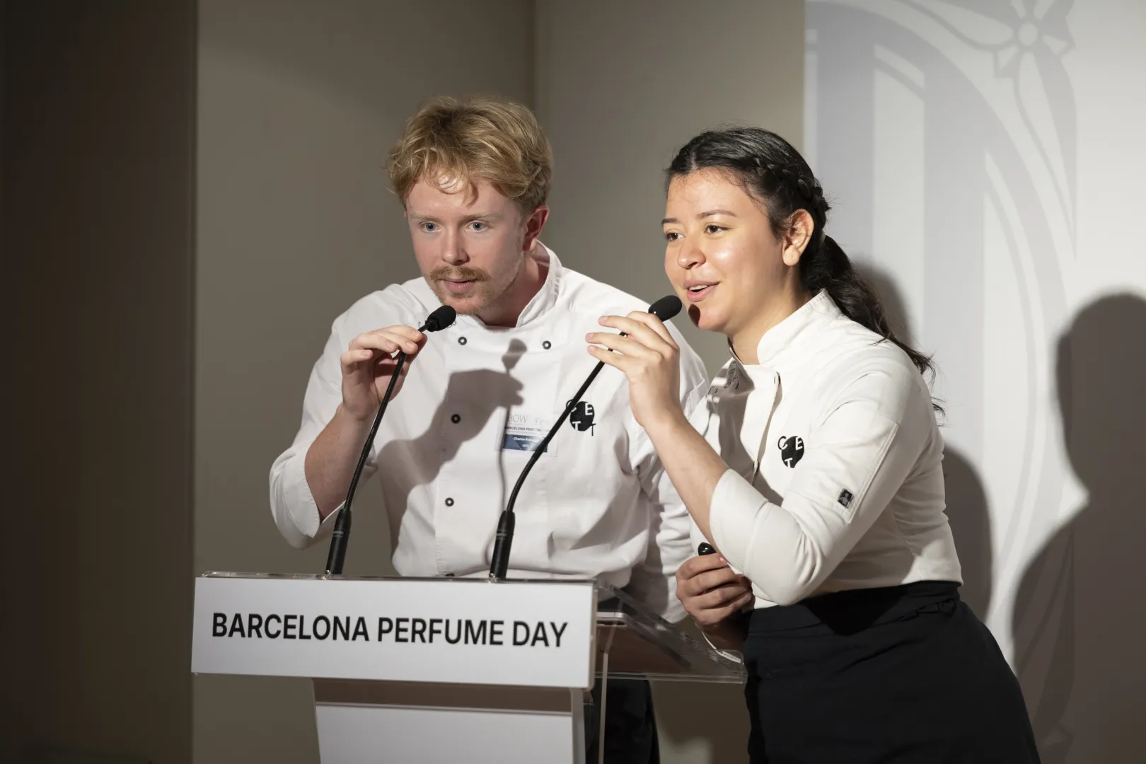 Dos alumnes del CETT presentant sobre l'escenari